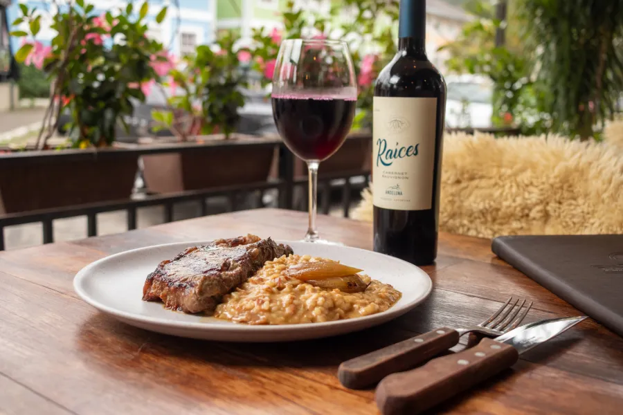 Corte de carne grelhado, com marcas da grelha, servido com risoto.